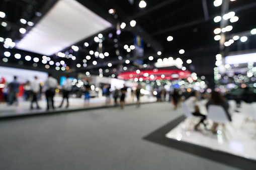 Blurred, defocused background of public event exhibition hall. Business trade show or commercial activity concept
